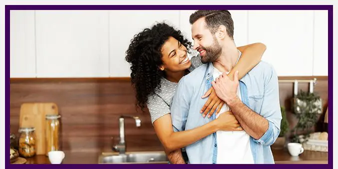 Close-up of a happy interracial couple standing in the kitchen