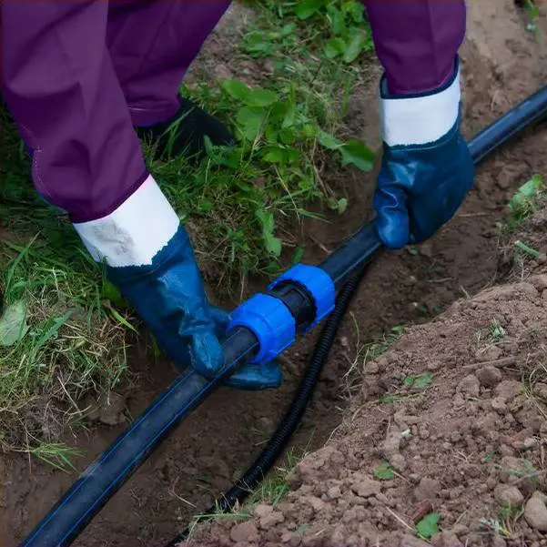 Man with glove checking underground pipe line