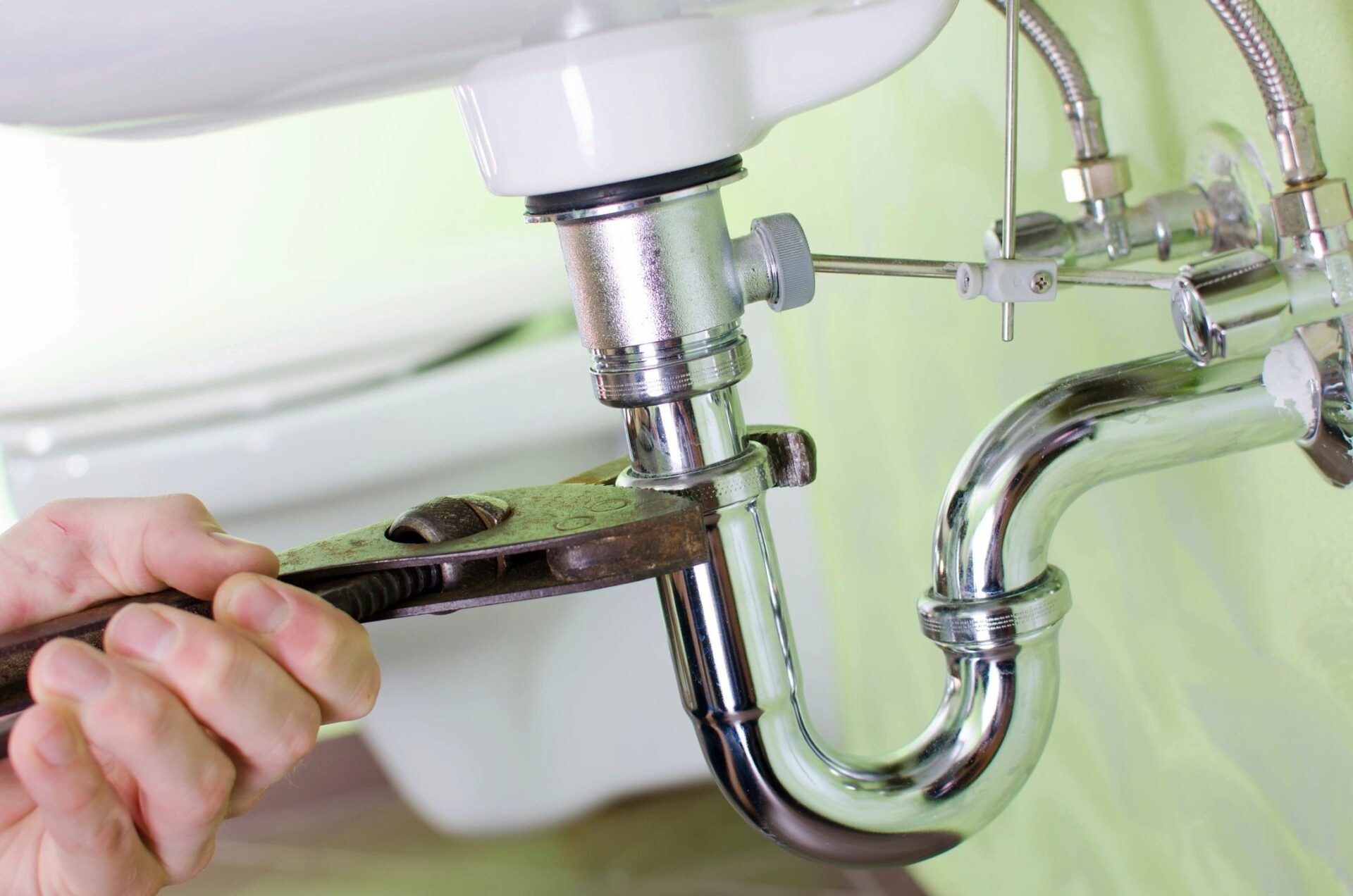 Close-up Of Male Plumber Fitting Sink Pipe In Bathroom